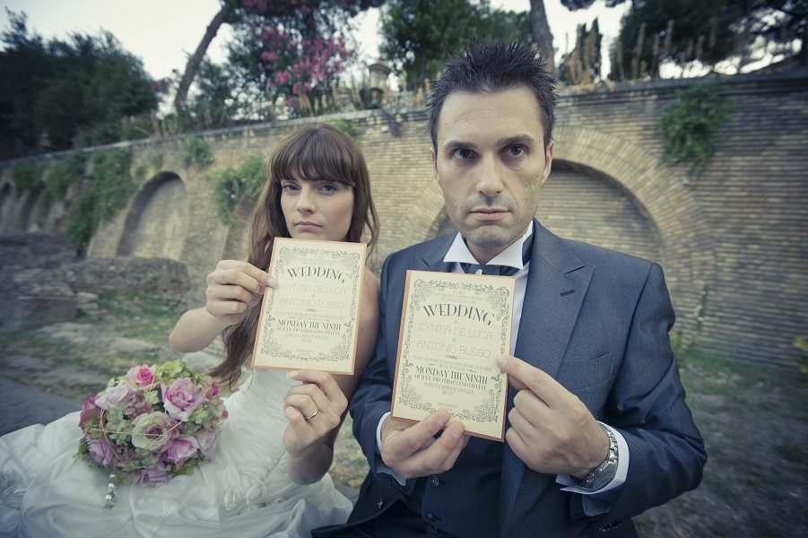 Cyntia and Claudio holding wedding invitations