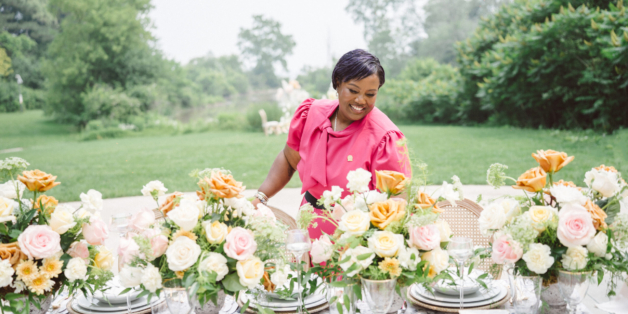 Certified wedding planner adjusting flowers on table at wedding