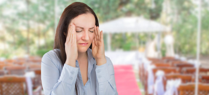 stressed out wedding planner rubbing temples at wedding