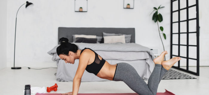 woman doing a plank in front of her bed