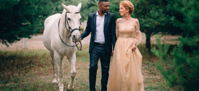 bride and groom walking with horse
