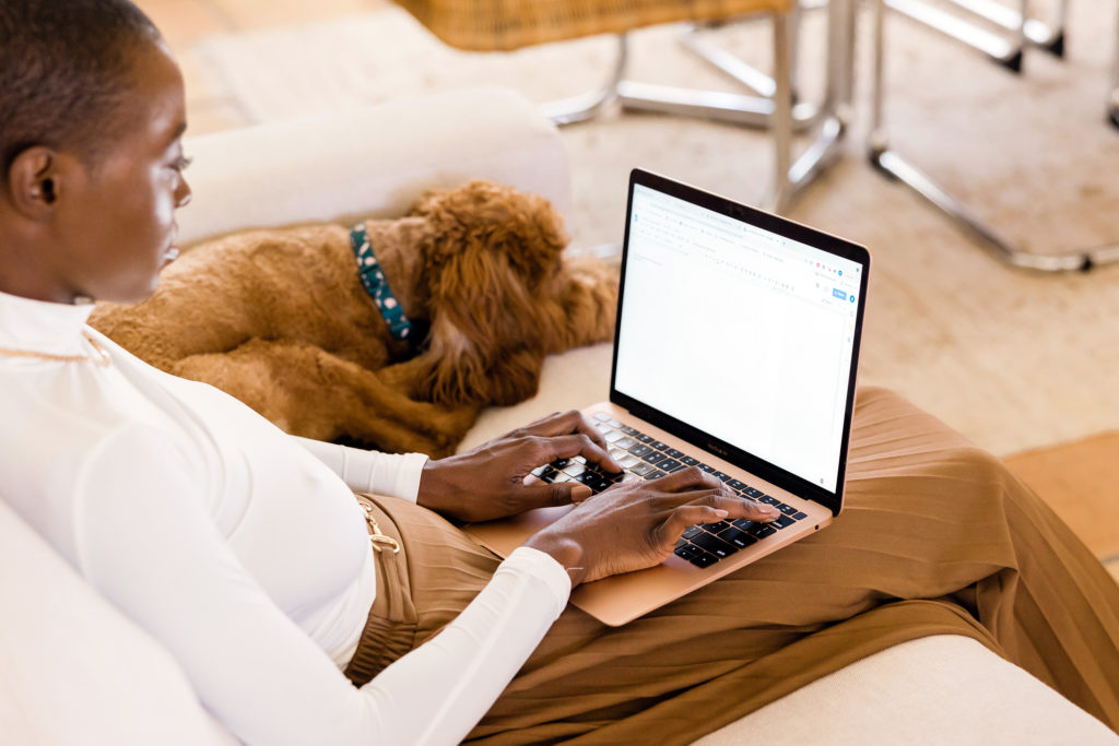 woman working on laptop beside dog