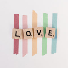 Scrabble pieces spelling LOVE on pride ribbons LGBTQ