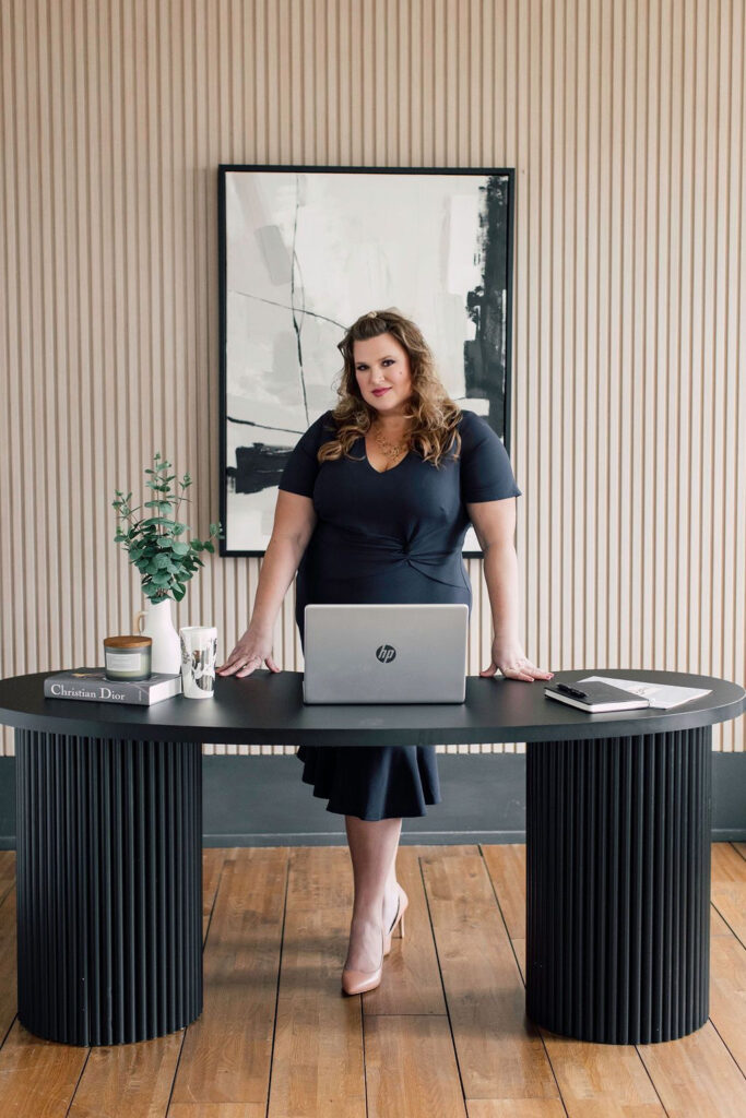 Powerful photo of Danielle Andrews, President of The Wedding Planners Institute of Canada standing behind desk