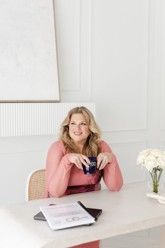 Wedding Planner, Danielle Andrews, sitting at desk with a coffee and wedding planner certification textbook