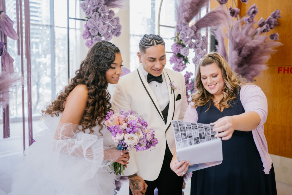 wedding planner with wedding brde and groom on wedding day looking at clipboard
