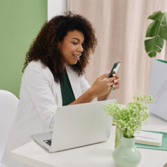 wedding planner typing on phone in front of computer. social media management