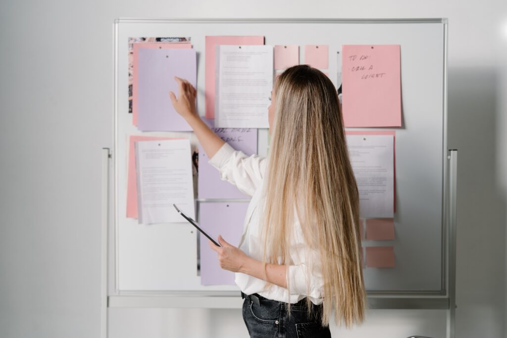 Wedding planner looking at her to do list on a white board
