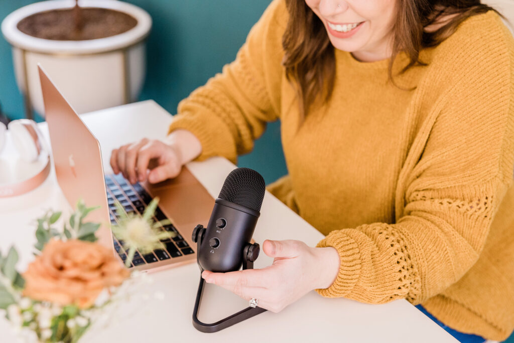 social media creator with mic at laptop