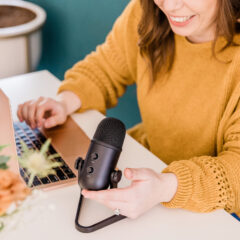 social media creator with mic at laptop