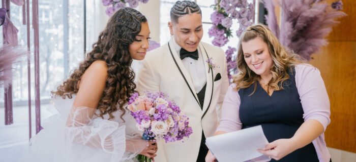 Wedding couple with their wedding planner looking at a clipboard