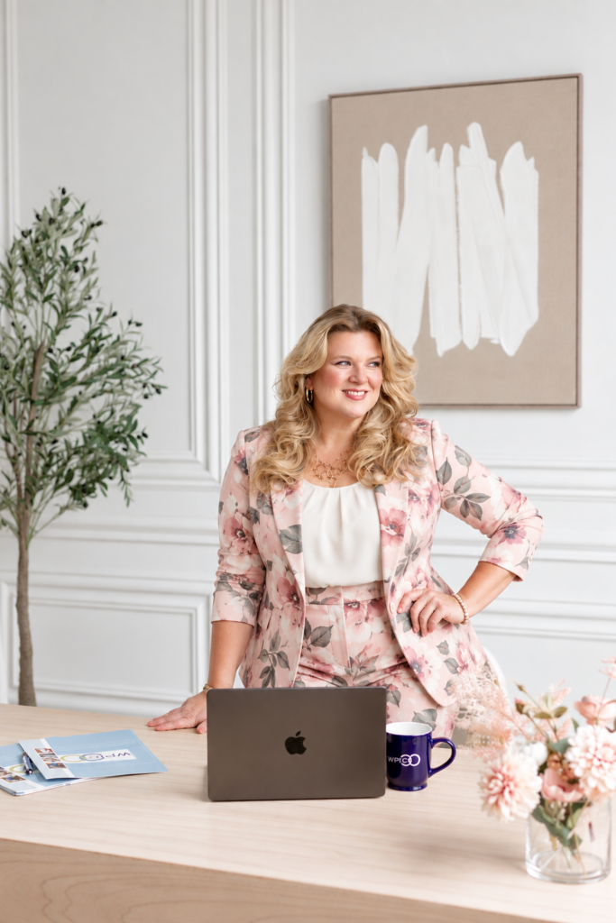 Danielle Andrews, President and Co-Founder of The Wedding Planners Institute of Canada, in WPIC Office in a pink floral suit